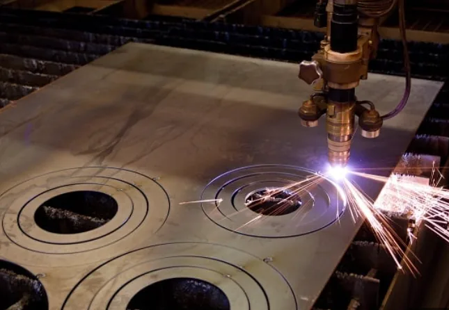 Close-up of a plasma torch cutting concentric rings into steel plate